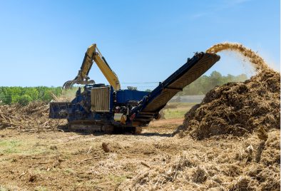 Machine chipping wood in a field.